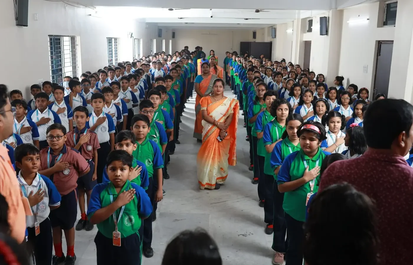 Students and teachers taking the school pledge at morning assembly