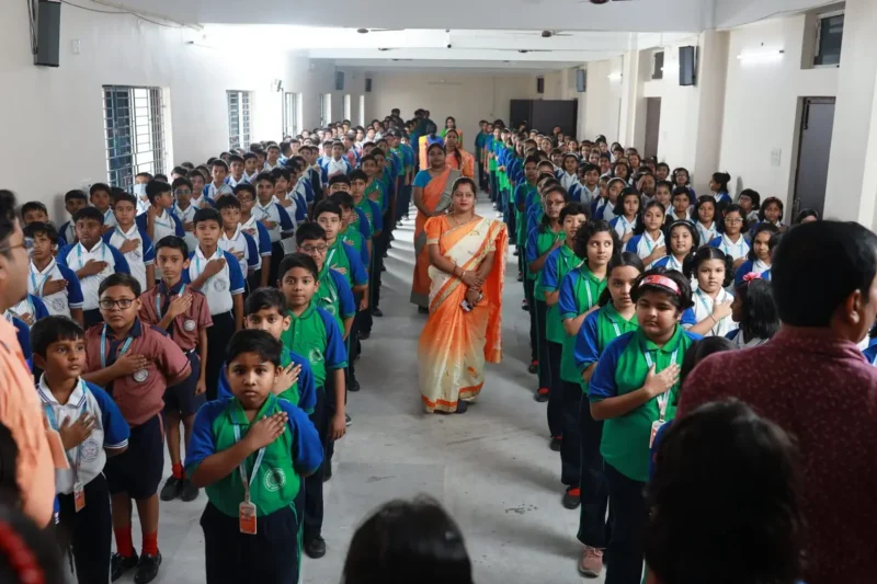 Students and teachers taking the school pledge at morning assembly