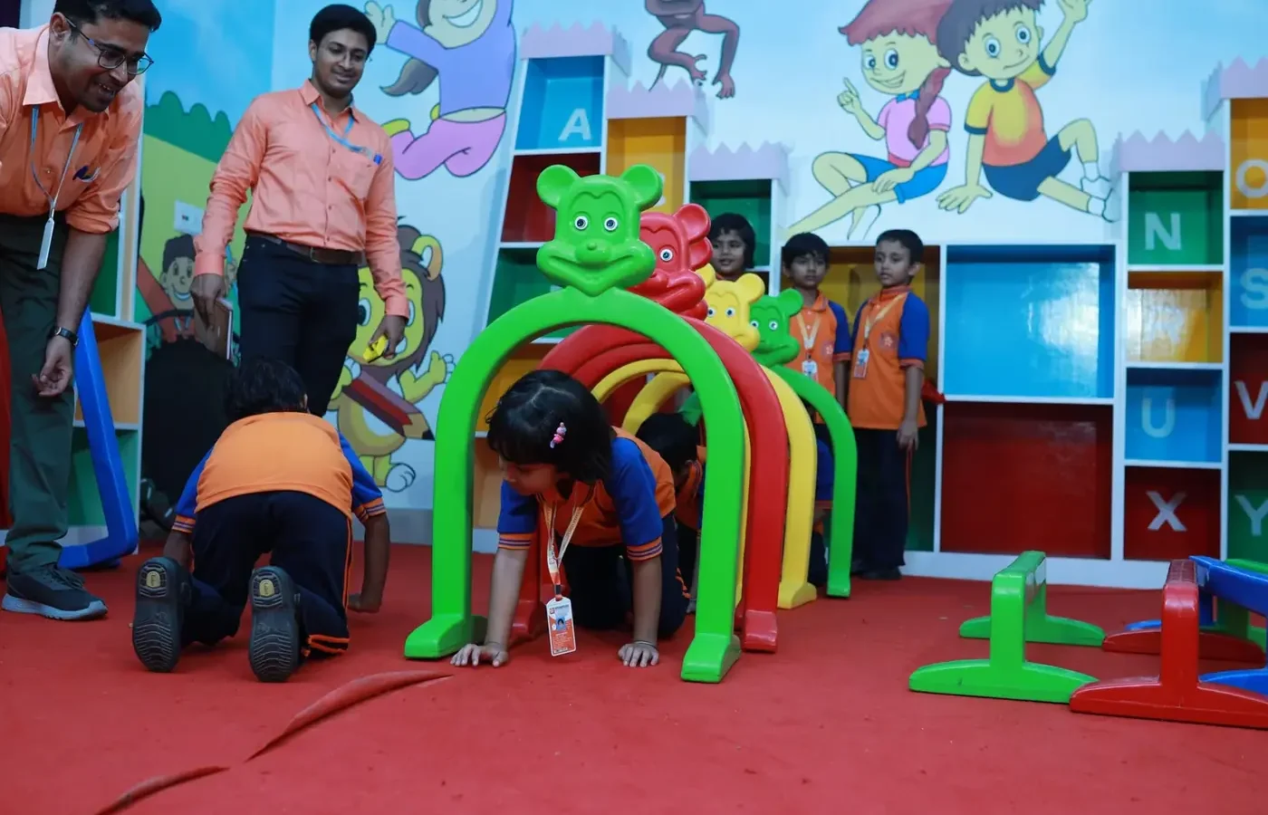 Children crawling through a soft-play tunnel in the indoor activity room