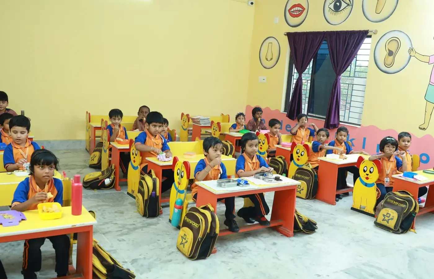 Pre-primary children at their desks in a decorated classroom