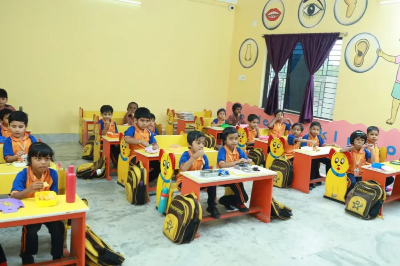 Pre-primary children at their desks in a decorated classroom